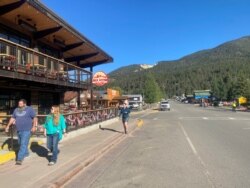 People walk on Main St without masks in violation of a health order by New Mexico Governor Michelle Lujan Grisham, amid the coronavirus disease (COVID-19) outbreak, in Red River, New Mexico, U.S., July 10, 2020. (REUTERS/Andrew Hay)