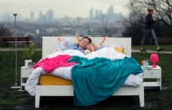 A couple lay in a double bed during a photo opportunity organised by the Mental Health Foundation to mark World Sleep Day, on Parliament Hill, in London, March 15, 2018.