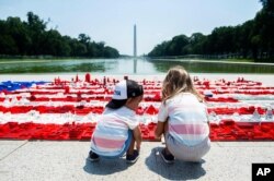미국 독립기념일을 하루 앞둔 7월 3일, 워싱턴 d.c.의 링컨 기념관 앞에서 어린아이들이 레고로 만든 성조기를 보고 있다.