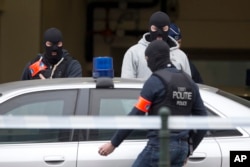 FILE - Police officers get into a vehicle outside a court building where Salah Abdeslam, the top suspect in the deadly, IS-claimed Paris attacks of the previous year, was expected to appear before a judge in Brussels, Belgium, March 24, 2016.