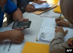 Para kerabat penumpang pesawat Lion Air JT610 yang jatuh di lepas pantai Karawang, menyerahkan dokumen dan foto kerabat mereka ke unit identifikasi korban di Rumah Sakit Polri, Jakarta, 30 Oktober 2018.