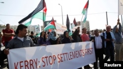Palestinians protesters hold a banner during demonstation in the West Bank town of Bethlehem, Nov. 6, 2013.