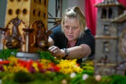 Stephanie Winters fills in the landscaping around a Coney Island themed display, Nov. 11, 2021.