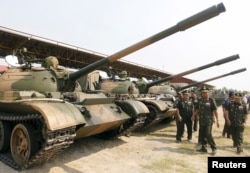 FILE - Cambodia's Deputy Prime Minister and Defence Minister Tea Banh (2nd R) inspects tanks inside the Army Institute after a graduation ceremony at Army Institute in Kampong Speu province March 12, 2015. When Defence Minister Tea Banh addressed graduates last month at Cambodia's prestigious Army Institute, he directed his thanks to the guests who made it all possible: a group of crisply dressed officers from China's People's Liberation Army (PLA). Military aid, alongside arms sales and billions of dollars of investment, have strengthened China's ties with Cambodia, and analysts see it as part of a push to extend regional influence, including in the disputed South China Sea. Picture taken March 12, 2015. (REUTERS/Samrang Pring)