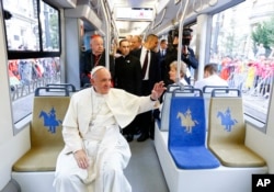 Pope Francis waves to a cheering crowd of faithful as he drives by in a public transportation tram he used to reach the venue of the World Youth Days in Krakow, July 28, 2016.