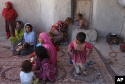FILE - In this Monday, May 30, 2016 photo, Afghan internally displaced family are seen at their temporary home in a camp for internally displaced people in Kabul, Afghanistan.