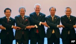 U.S. State Secretary Rex Tillerson, center, links arms with ASEAN foreign ministers as they take part in the ASEAN-U.S. Ministerial meeting in the 50th ASEAN Regional Forum in suburban Pasay city, southeast of Manila, Aug.6, 2017.