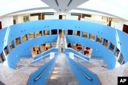FILE - A man walks along a pathway in the Texas A&M University campus at Education City in Doha, Qatar, in this 2011 photo.