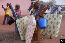 FILE - Civilians who fled their homes following an attack by Islamist militants in North East, Nigeria, receive relief materials from the government at the camp for internally displaced people in Yola, Nigeria, Jan. 27, 2015.