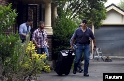 FILE- Australian Federal Police officers walk down the driveway after searching the home of probable creator of cryptocurrency bitcoin Craig Steven Wright in Sydney's north shore, Dec. 9, 2015.