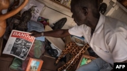 Un vendeur de souvenirs montre des documents portant l'effigie de Bokassa à Bangui, le 17 septembre 2019.