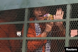 Member of the dissolved opposition Cambodia National Rescue Party (CNRP) Ouk Pich Samnang reacts inside a police vehicle on his way to attend a verdict announcement at the appeal court in Phnom Penh, Cambodia, May 10, 2018.