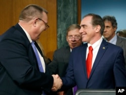 FILE - The Senate Veterans' Affairs Committee Ranking member Jon Tester, D-Mont., left, with committee chairman Sen. Johnny Isakson, R-Ga., center, shakes hands with Veterans Affairs Secretary-designate Dr. David Shulkin on Capitol Hill.