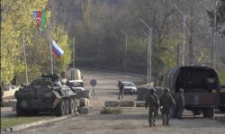 Pengambilan gambar dari video AFPTV ini menunjukkan bendera Rusia dan Azerbaijan berkibar di samping penjaga perdamaian Rusia di pos pemeriksaan dekat Shusha di sepanjang jalan Goris-Stepanakert, 17 November 2020.