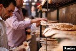 Men arrange bread to cool down in Damascus, Syria, Sept. 17, 2016.