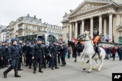 Police secure a zone around a police bus for detained people, at the Place de la Bourse in Brussels, Belgium, April 2, 2016.
