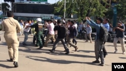 ក្រុម​សន្តិសុខ​រារាំង​បងប្អូន​ប្រុស​ភ្លោះ​លោក ជុំ ហួត និង​លោក ជុំ ហួរ មិន​ឲ្យ​យក​កម្រង​ផ្កា​ដាក់​ កន្លែង​ដែល​លោក កែម ឡី ត្រូវ​ឃាតករ​បាញ់​សម្លាប់​ក្នុង​ម៉ាត​របស់​ស្ថានីយ៍​ប្រេងសាំង​កាល់តិច ក្នុង​ខណ្ឌ​ចំការ​មន រាជធានី​ភ្នំពេញ នៅថ្ងៃទី​១០ ខែ​កក្កដា ឆ្នាំ២០១៩។ (ហ៊ុល រស្មី/VOA)