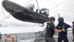 Members of Sea Shepherd, an ocean conservation group, lower an inflatable dinghy from the deck of the Ocean Warrior off the west coast of South America on July 17, 2021.