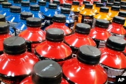 FILE - Sodas and energy drinks line the shelves in a grocery store in Springfield, Illinois, May 18, 2016. The World Health Organization recommends countries use tax policy to increase the price of sugary drinks as a way to fight obesity and diabetes.