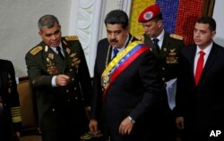 FILE - Venezuela's President Nicolas Maduro, center, stands with his Defense Minister Vladimir Padrino Lopez before giving his annual address Jan. 14, 2019