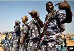 Members of South Sudanese military escort accompanying returnees from North Sudan as they enter Abyei