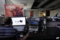 An employee at Sphero, a fast-growing toy robotics company, works surrounded by Star Wars toys and posters, at the company headquarters in Boulder, Colorado, July 24, 2015.