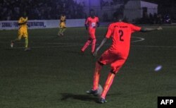 Football players from Hodan district (orange) and Waberi district (yellow) play in the first nighttime game in 30 years in Modadishu, Somalia, Sept. 8, 2017.