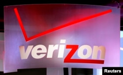 FILE - A Verizon sign is seen displayed at an electronics show.