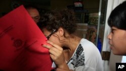 Heather Mack, menutupi wajahnya, dibawa ke rumah sakit untuk pemeriksaan medis, Agustus.