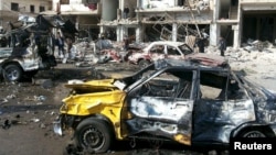 People inspect the site of a two bomb blasts in the mostly government-controlled city of Homs, Syria, in this handout picture provided by SANA on Feb 21, 2016.