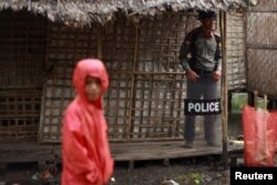 FILE - A policeman stands guard as former U.N. chief Kofi Annan (not in picture) attends a meeting with local leaders at the Aung Mingalar Rohingya internally displaced persons (IDP) camp in Sittwe, Myanmar, Sept. 7, 2016.