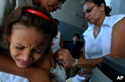 FILE - A girl is vaccinated against measles at a Health clinic in Managua, Nicaragua, Nov, 30, 2005.