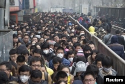 2015年12月8日，在北京首次发布空气污染红色警报后，乘客在地铁站排队。