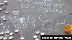 Arabic text written at Place de la Republique pays triibute to the victims of last week's Paris attacks, in which 129 people were killed, Paris, Nov. 16, 2015. (Photo - L. Bryant/VOA)