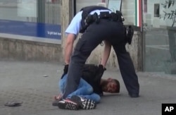 In this grab taken from video, police arrest a man in Reutilingen, Germany, July 24, 2016. A Syrian man killed a woman with a machete and wounded two others outside a bus station in the southwestern city before being arrested.