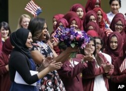 U.S. first lady Michelle Obama is greeted by pupils and teachers at Mulberry School for Girls in east London, June 16, 2015.