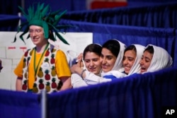 Team Afghanistan, from second from left, Kawsar Roshan, Lida Azizi, Somayeh Faruqi and Rodaba Noori, next to a member of Team Australia, at left, hug before their final round of competition at the FIRST Global Robotics Challenge, July 18, 2017, in Washington.