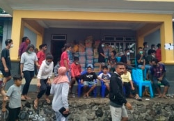 Warga yang terdampak banjir bandang akibat siklon tropis Seroja mendatangi tempat distribusi bantuan di Ile Boleng di Pulau Adonara, Nusa Tenggara Timur, 7 April 2021. (Foto: Rofinus Monteiro/AP)