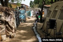 A child walks over a stream of dirty water at the EYN CAN Center internally displaced persons camp in Maiduguri, Nigeria on March 24, 2016.