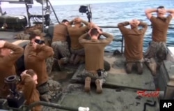 FILE - This photo, released by the Iranian state-run IRIB News Agency Jan. 13, 2016, shows detention of U.S. Navy sailors by the Iranian Revolutionary Guards in the Persian Gulf, Iran.