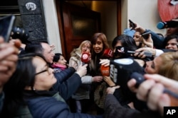 Former President Cristina Fernandez is surrounded by media outside her home as she leaves for a court hearing, in Buenos Aires, Argentina, Aug. 13, 2018.