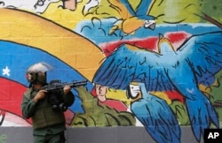 A National Guard soldier points his weapon during clashes with anti-government demonstrations in the streets of Caracas, Venezuela, July 20, 2017.