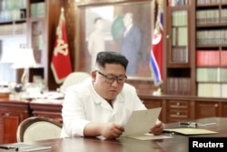 North Korean leader Kim Jong Un reads a letter from U.S. President Donald Trump, in Pyongyang, North Korea, in this picture released by North Korea's Korean Central News Agency, June 22, 2019.