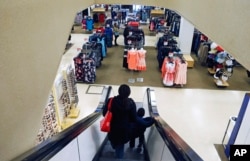 In this March 22, 2017, file photo, a woman and child ride the escalator at a Sears store in St. Paul, Minnesota.