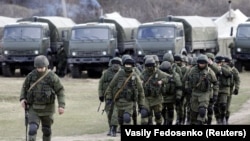 UKRAINE – Uniformed men, believed to be Russian servicemen, walk in formation near a Ukrainian military base in the village of Perevalnoye outside Simferopol, March 6, 2014