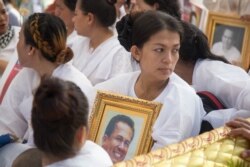 រូបឯកសារ៖ អ្នកស្រី ប៊ូ រចនា ភរិយា​សព​លោក​ កែម ឡី​ ​ឱប​រូបថតរបស់ស្វាមី​អ្នកស្រី​ ខណៈ​ពេល​អម​ដំណើរ​ដោយ​ប្រជា​ពលរដ្ឋ​រាប់​ម៉ឺន​នាក់​ចូល​រួម​ជូន​ដំណើរ​លោក​ កែម ឡី​ នៅ​ថ្ងៃ​អាទិត្យ​ ទី​២៤ ខែកក្កដា​ ឆ្នាំ២០១៦​។ (ឡេង ឡែន/វីអូអេ)