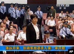 中央电视台画面显示薄熙来妻子谷开来(中间站立者)2012年8月9日在中国东部的合肥市中级人民法院出庭受审