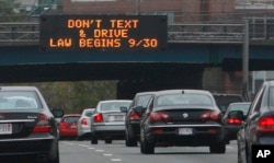In this photo taken Friday, Sept. 24, 2010, a sign over the Massachusetts Turnpike in Boston alerts motorists to a new state law banning texting while driving. (AP Photo/Bill Sikes)