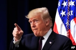President Donald Trump acknowledges applause as speaks during a conference supporting veterans and military families through partnership at the Eisenhower Executive Office Building at the White House complex in Washington, Nov. 15, 2018.