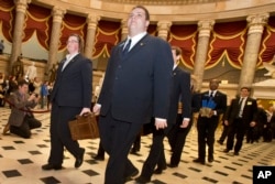 Pages lead a Senate procession carrying two boxes holding Electoral College votes through Statuary Hall to the House Chamber on Capitol Hill on Capitol Hill in Washington, Friday, Jan. 4, 2013, for the counting of the votes